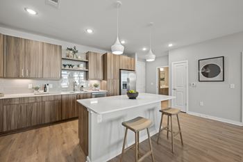 A modern kitchen with wooden cabinets and a white island.